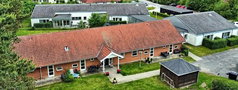 Tre bygninger sat sammen med overdækkede gange. 